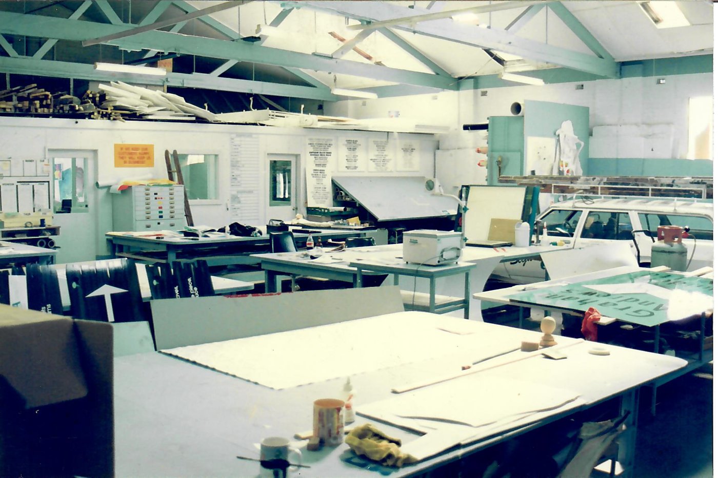 Inside the Alpha Lewis Signs workshop with signs in progress on the benches