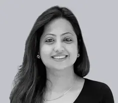 Portrait of a smiling woman with long hair against a plain background.