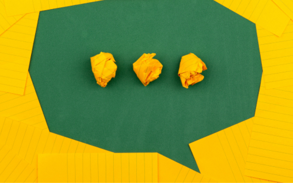 Speech bubble made of yellow paper representing team communication