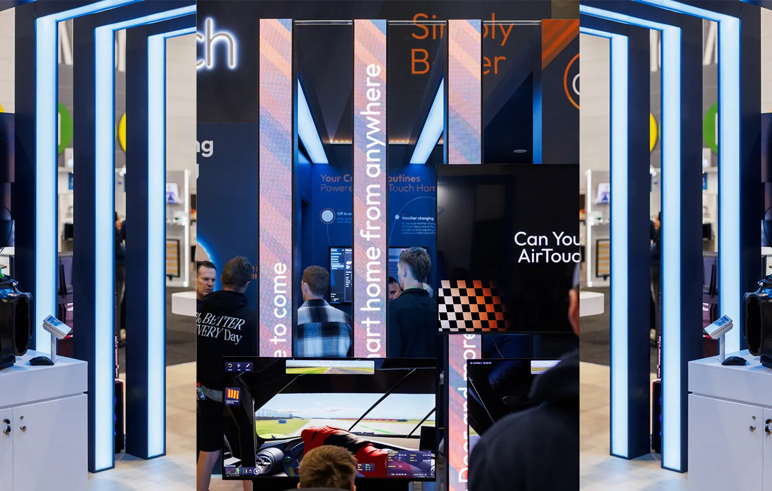 People interacting with digital displays and illuminated LED strip panels in a modern tech exhibit booth.