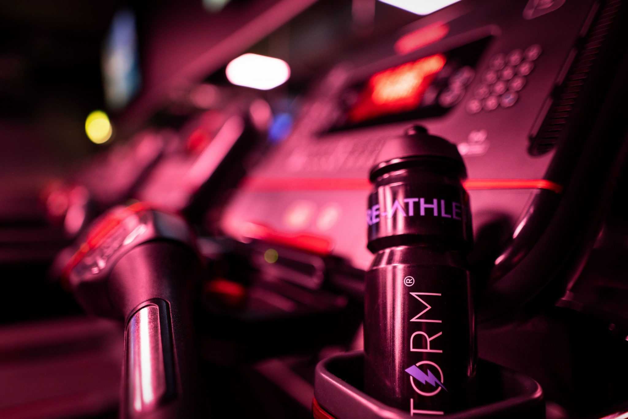A STORM water bottle is in a treadmill holder. 