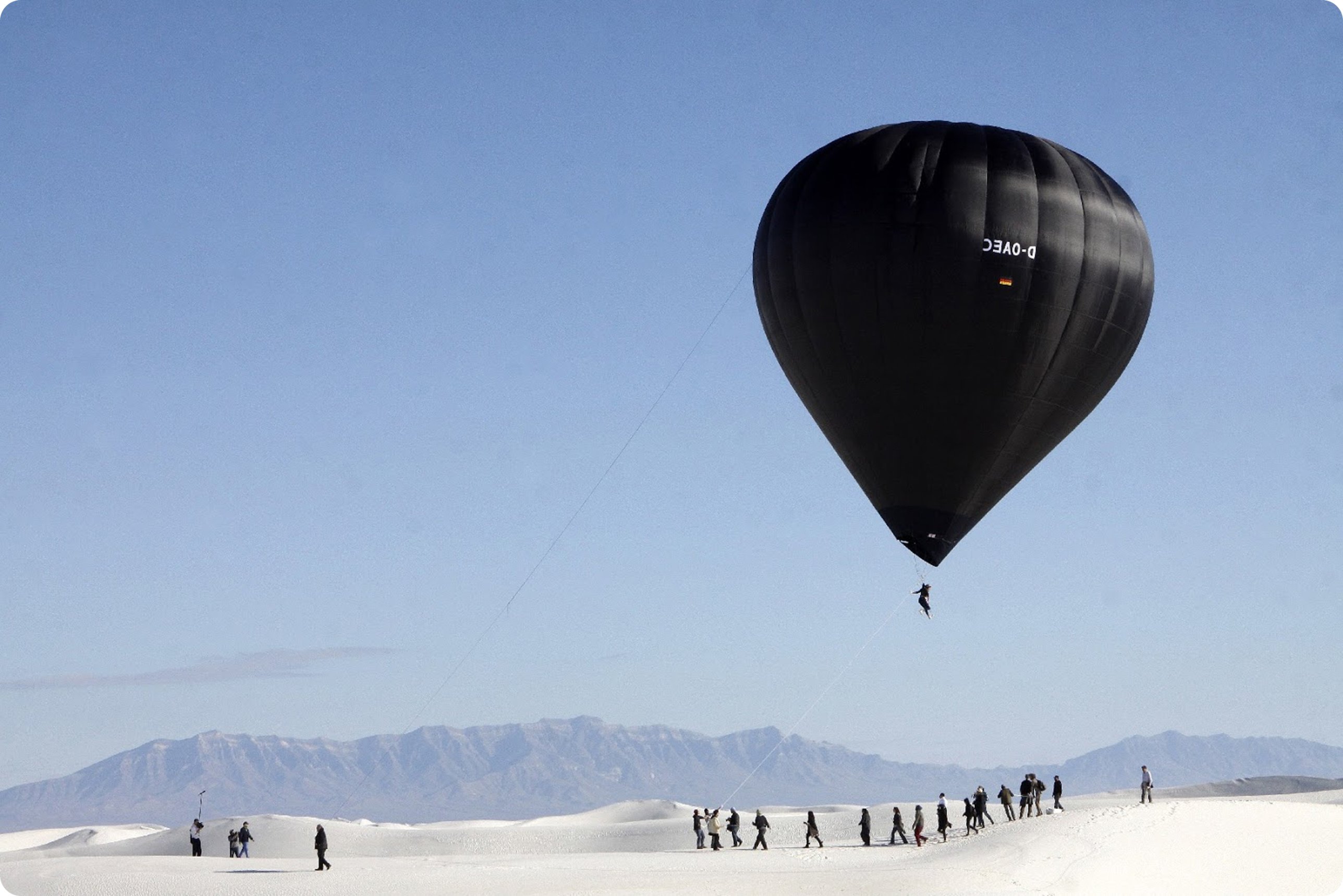 Montgolfière noire au-dessus d'un désert blanc