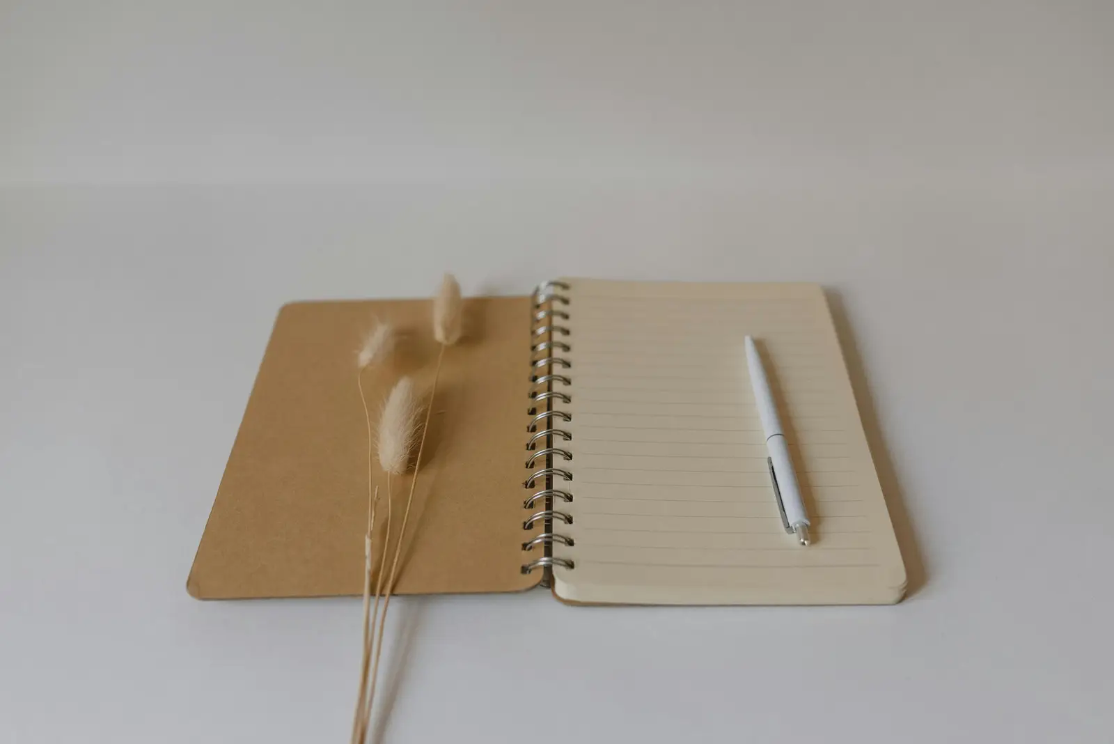 picture of a notebook with a blank page and a pen ready to be used to create new adhd friendly family systems