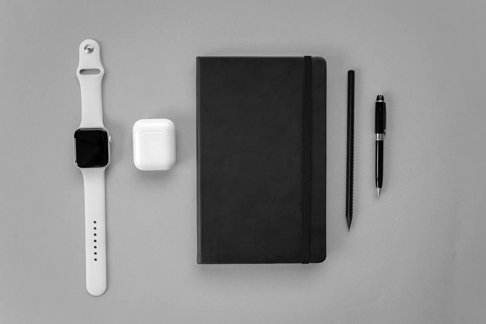 Picture of a notebook, pen, headphones and smartphone suggesting the tools in the present age
