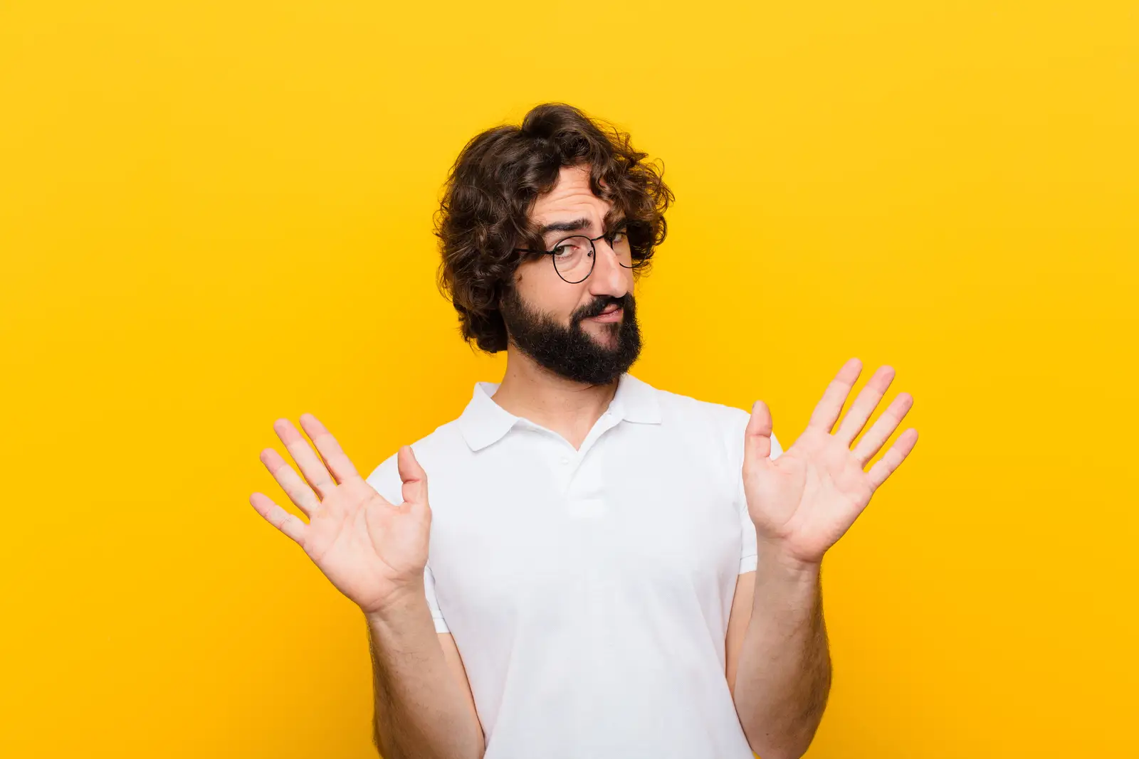 Picture of a man in his 30s having the body language suggesting that is not his fault and being defensive.