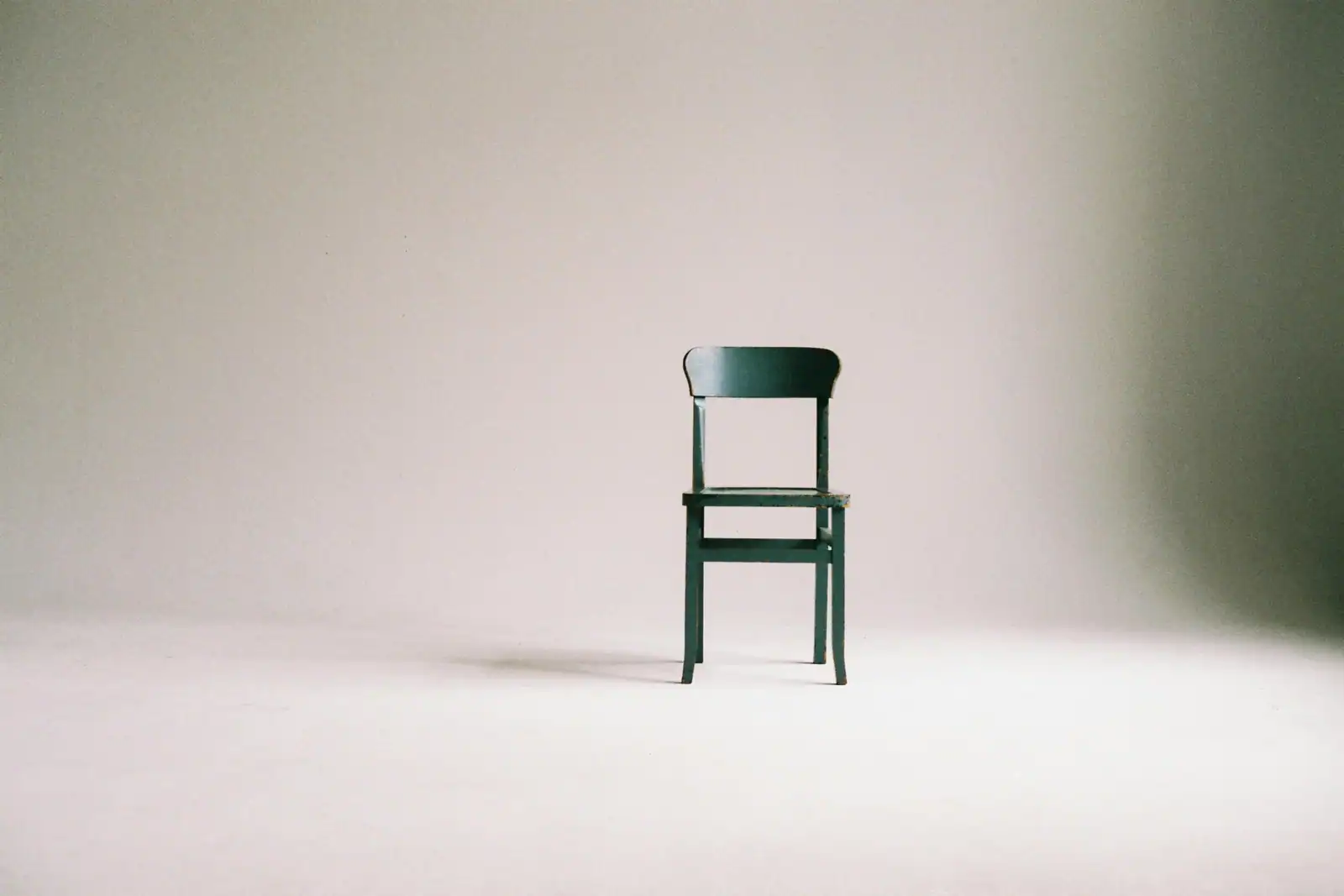 Picture of an empty chair in a minimalist background, suggesting concerns around a lack of attendance.