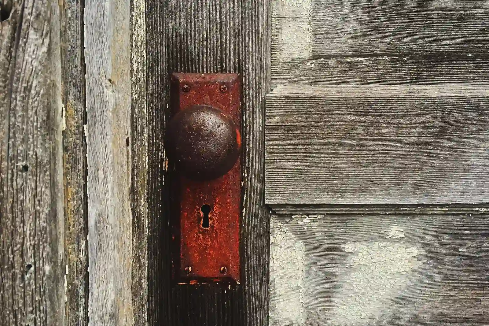Picture of a closed door with a rusty lock, suggesting the blanket rejection policies of some GP surgeries when it comes to ADHD shared care agreements. 