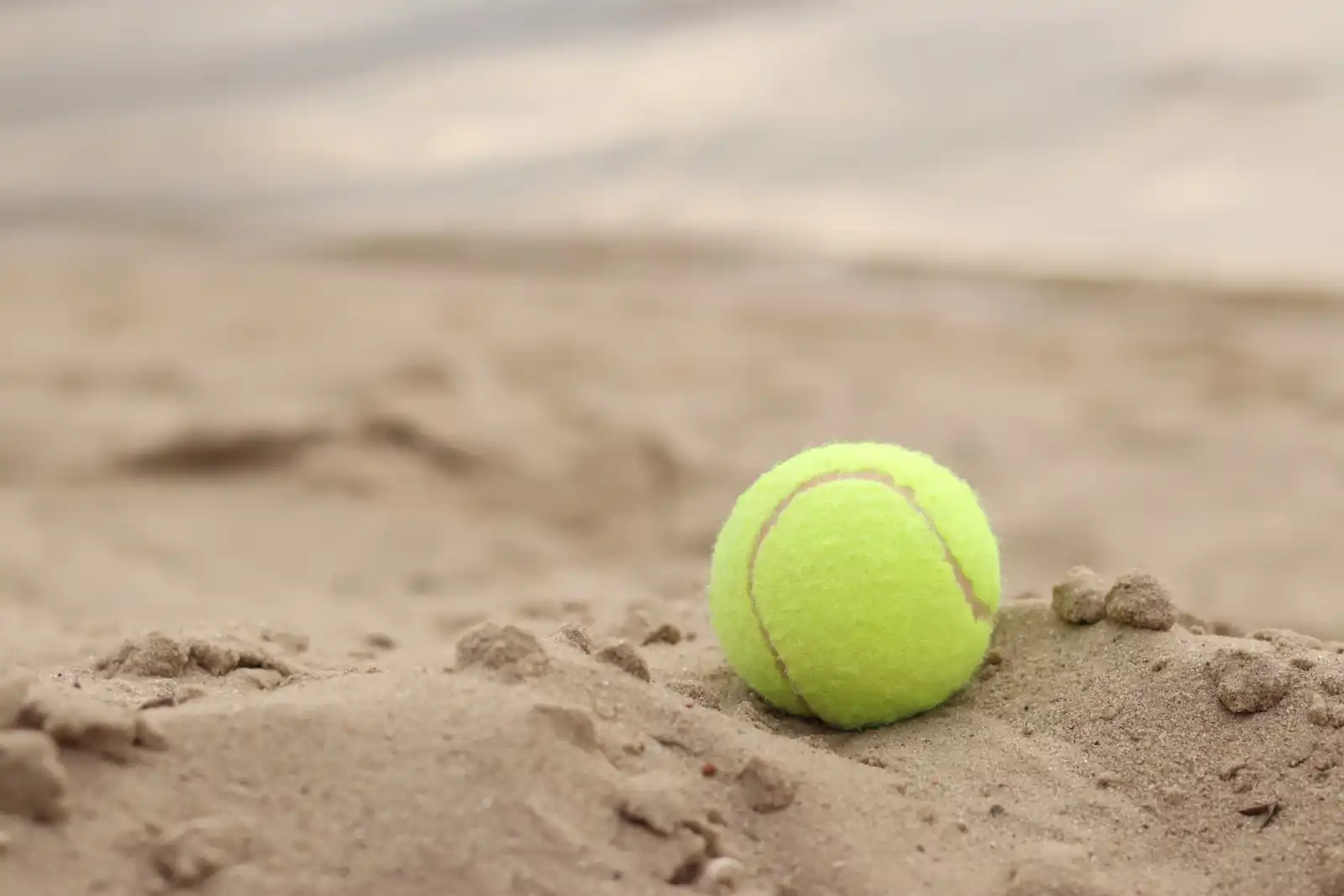 Picture of a tennis ball on the sand at the beach. Suggesting the difficulty that a GP could have if managing highly specialist medication which may be out of license for ADHD and managed only by the specialist. 