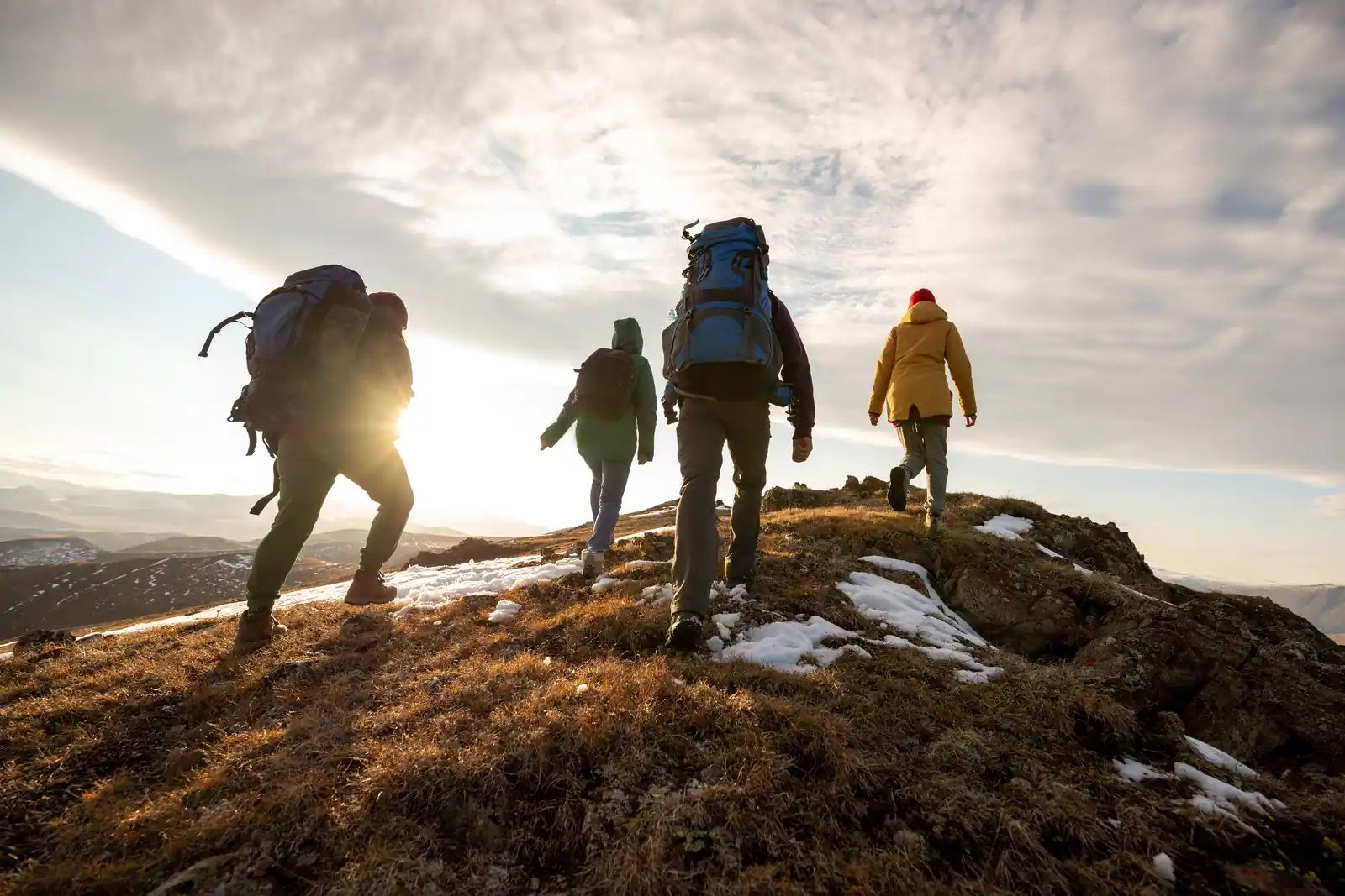 Small group of determined hikers climbing a mountain together. This suggests the importance of a long term partnership in a shared care agreement.