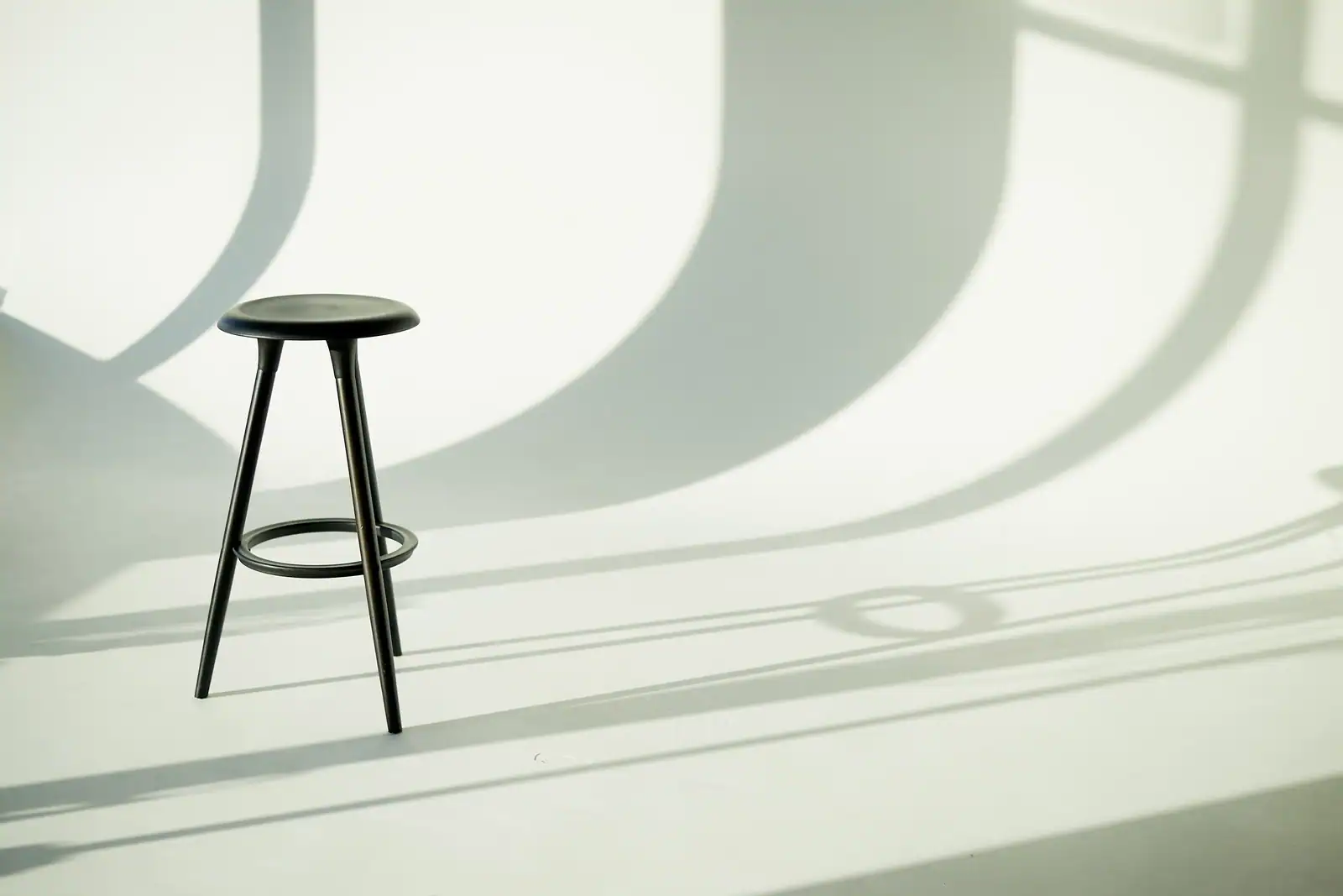 Minimalistic photo of a simple three legged stool. This suggests the importance of the specialist, the GP and the patient all working together.