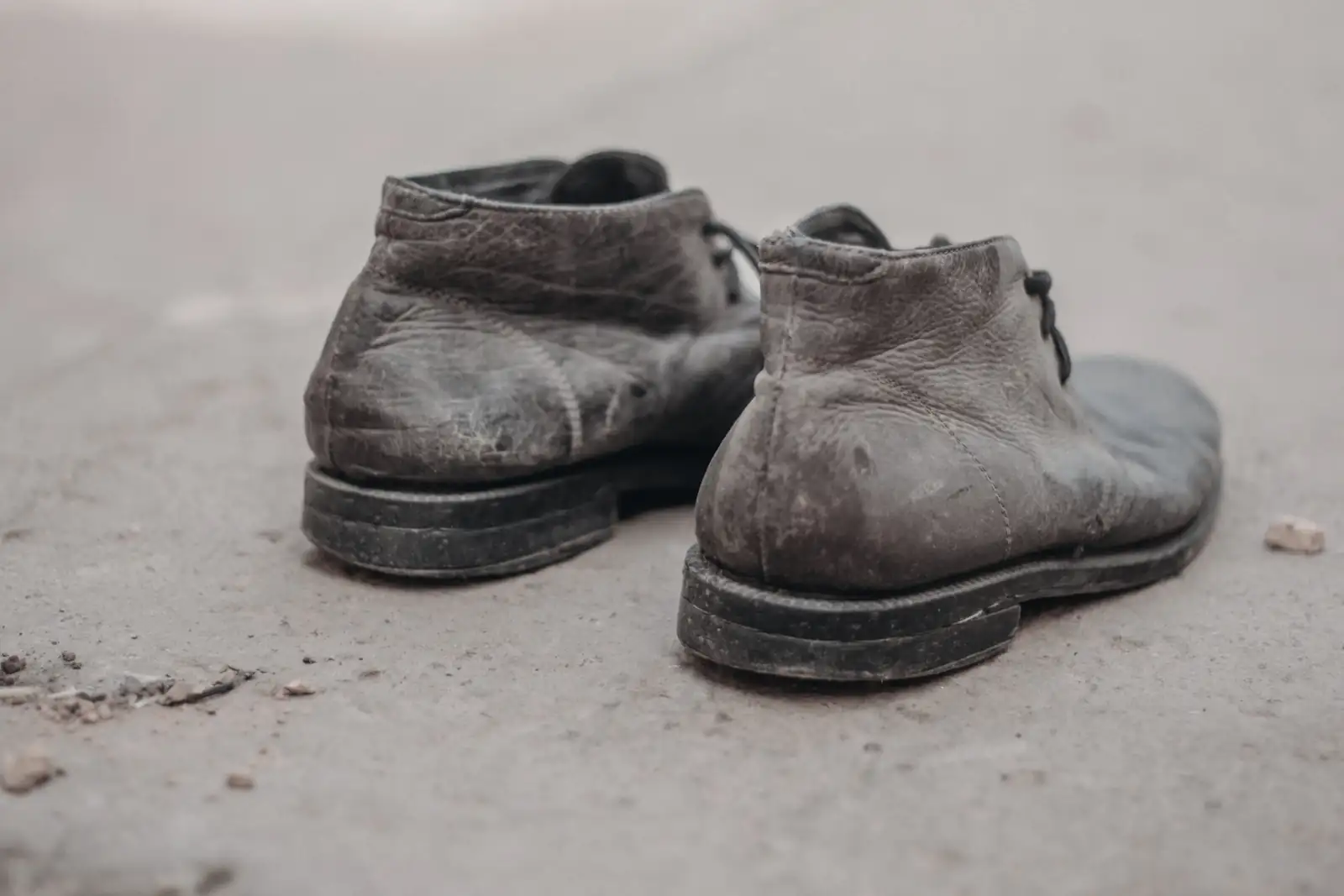 Black and white picture of a worn out and low-quality boots