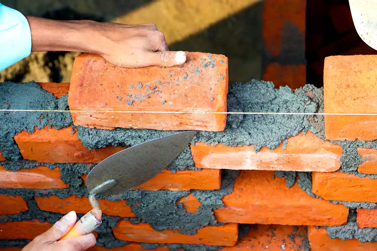 Picture of hands building a brick wall, suggesting the importance of building the right biological foundation for sustainable mental health. 