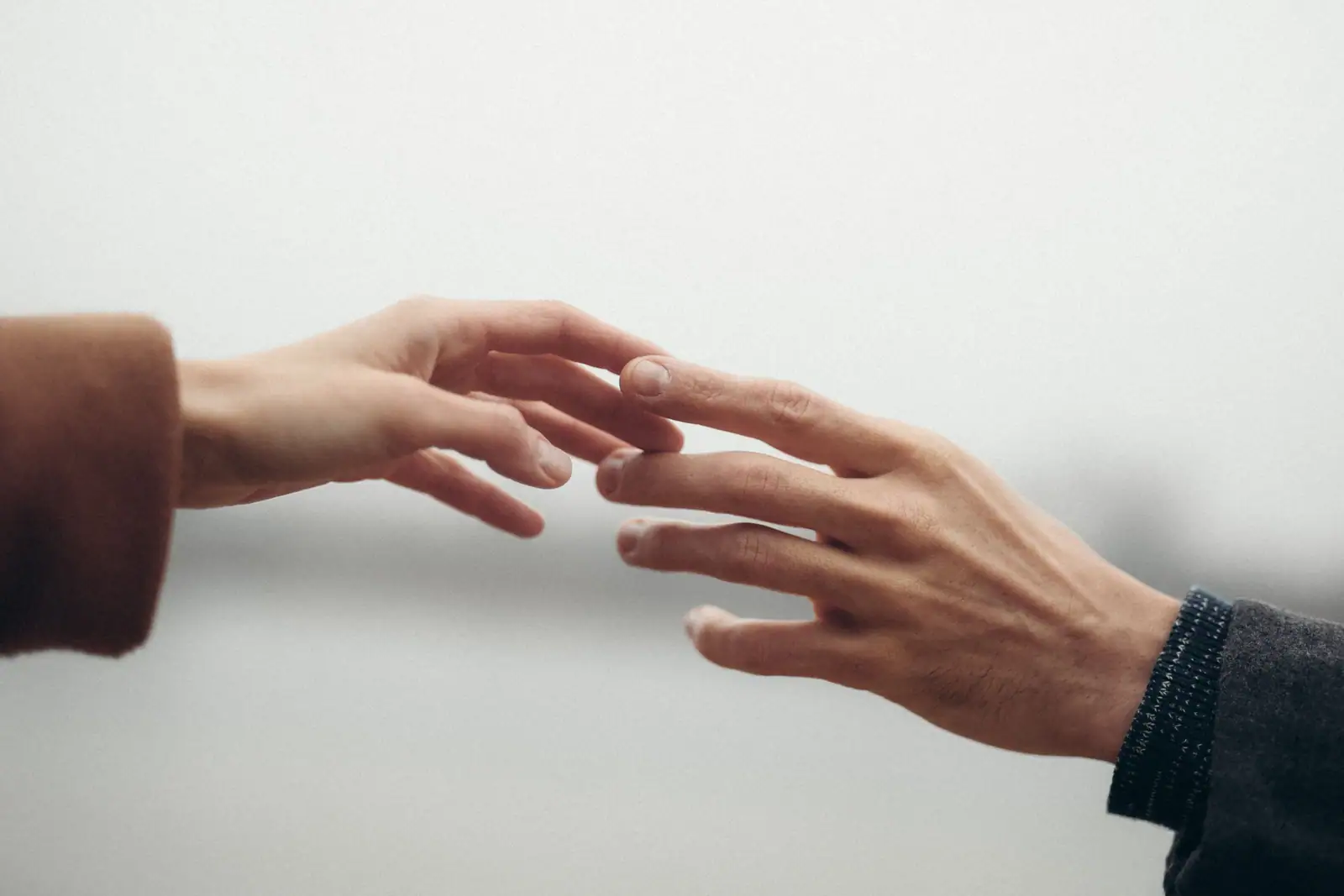 Picture of two human hands teaching for each other to connect suggesting human alliance. 