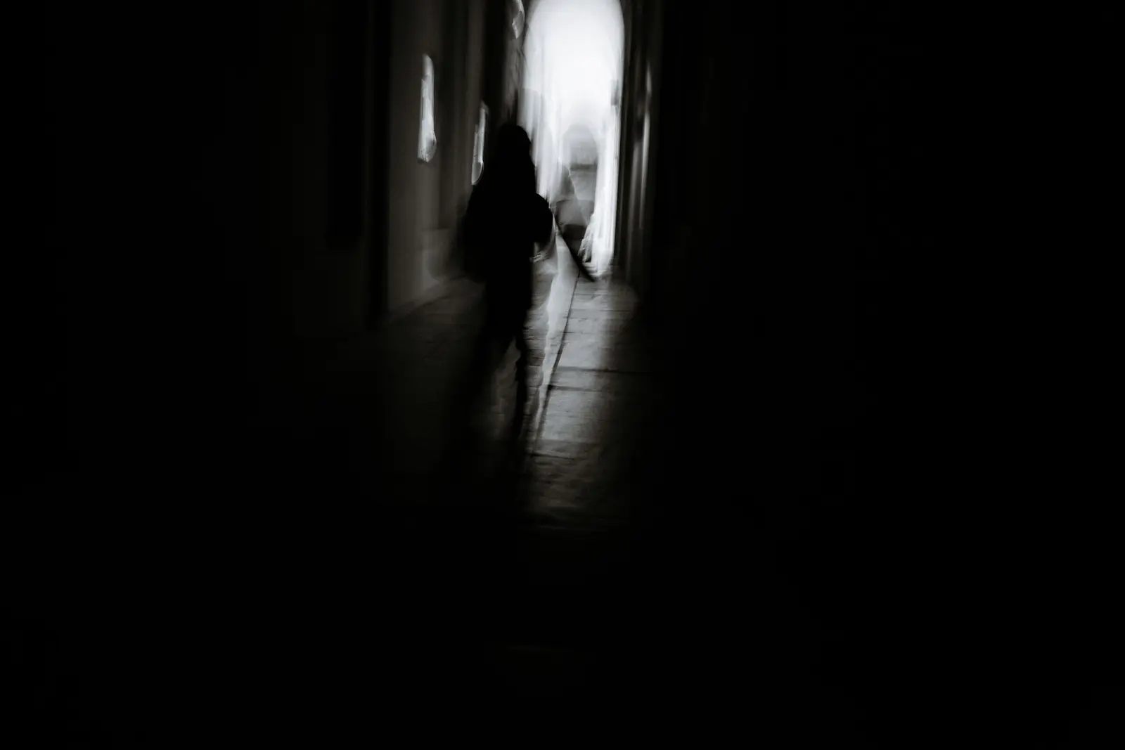 Image of a blurry person passing a tunnel waiting to fight or flight, artistic black and white photo