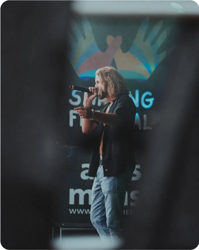 A person standing on stage and hosting an event