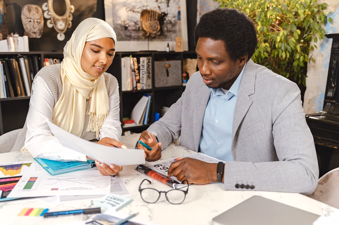 Two colleagues reviewing documents together in a workplace setting, supporting collaboration and open communication
