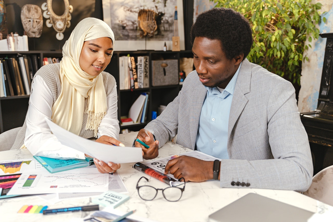 Two colleagues reviewing documents together in a workplace setting, supporting collaboration and open communication