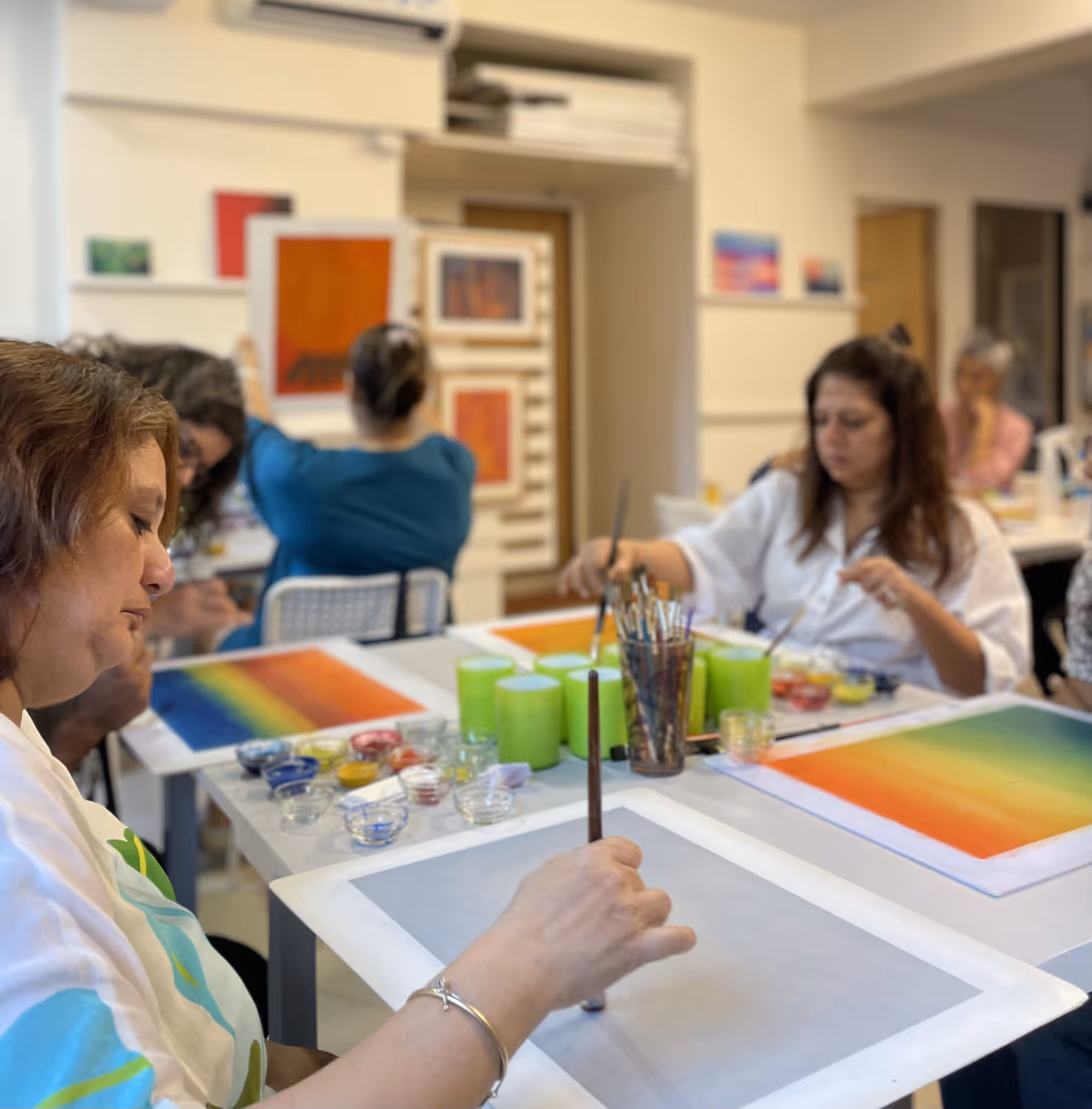 Employees participating in a group painting session, engaging in creative expression to relax and support mental well-being
