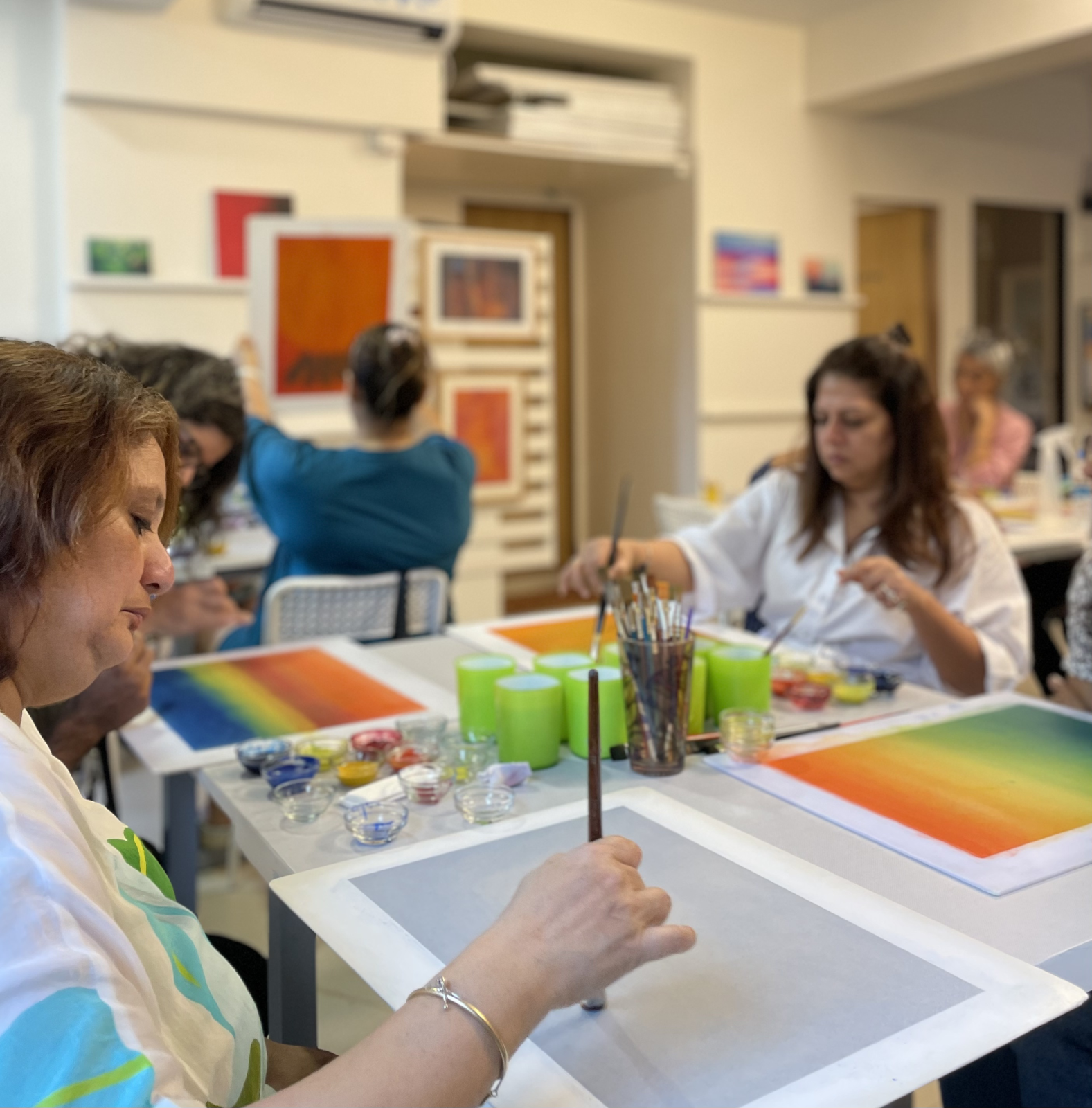Employees participating in a group painting session, engaging in creative expression to relax and support mental well-being