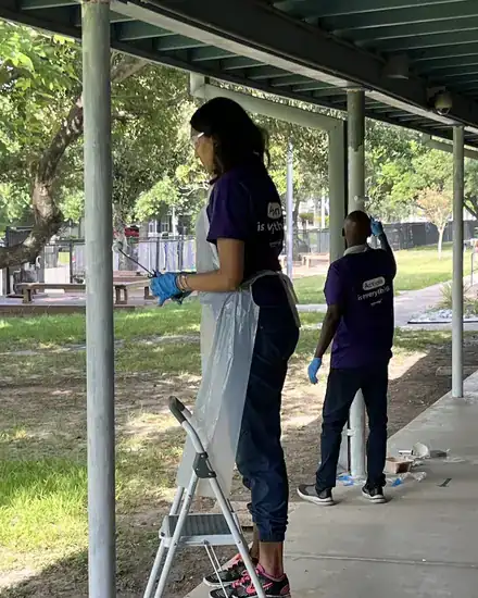 Volunteers repainting posts in a school courtyard