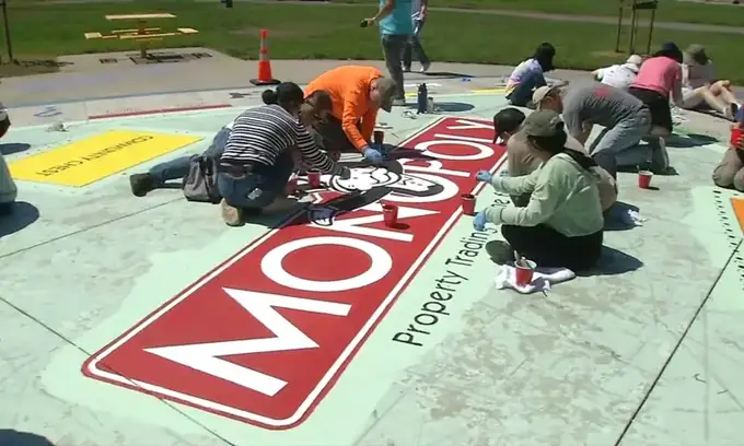 Volunteers repainting a giant walk-on Monopoly board