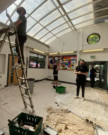 Volunteers repainting a school hall
