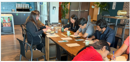 Volunteers writing connection letters at a table