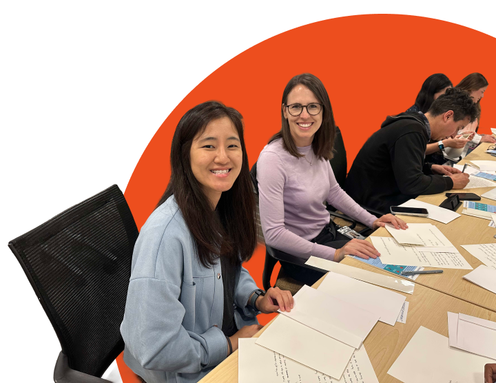 Volunteers writing welcome letters together at a table