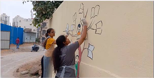 Volunteers painting a bright mural on a wall