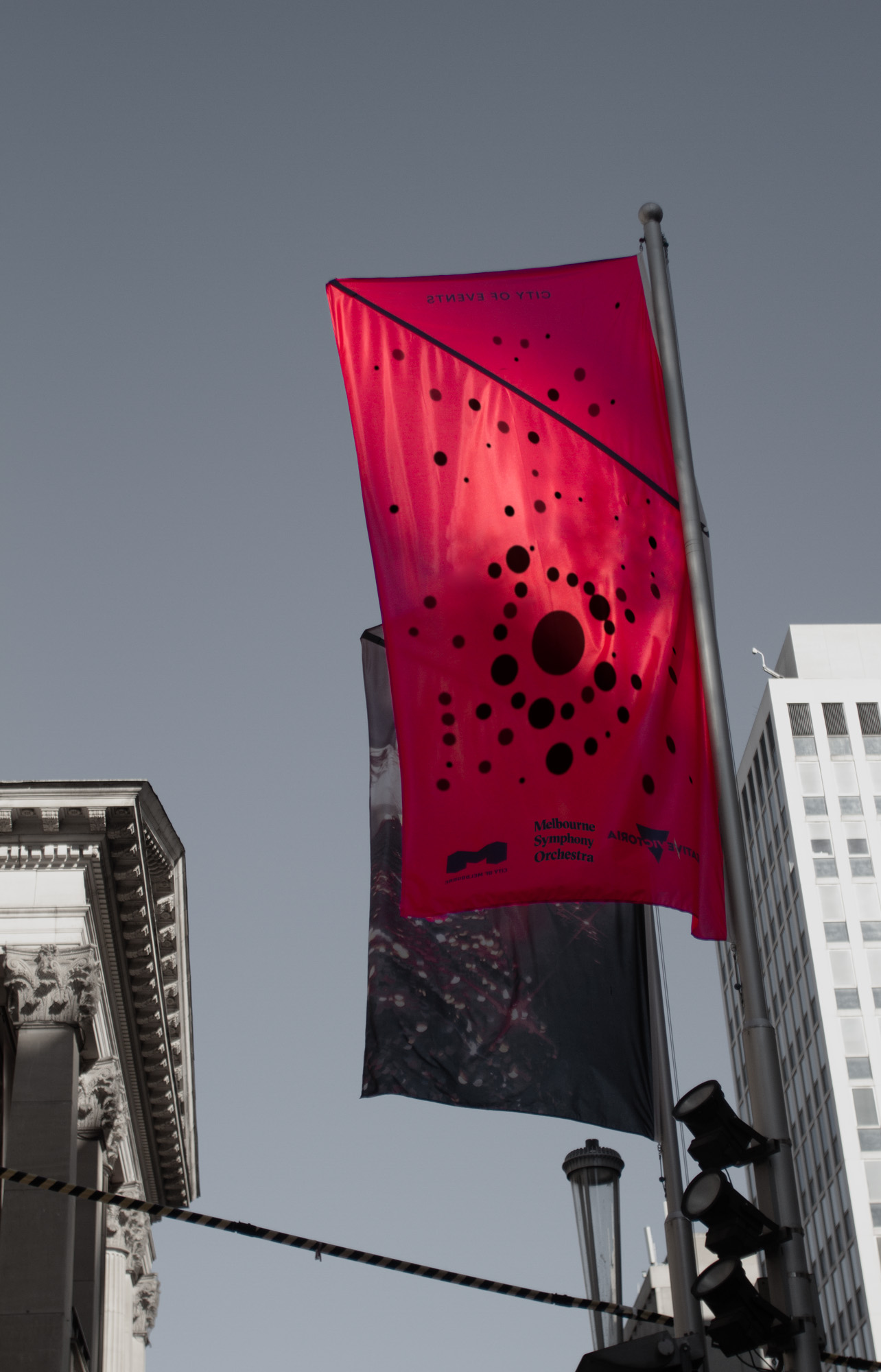 A red flag waving in the wind with a sound visualisation printed on it