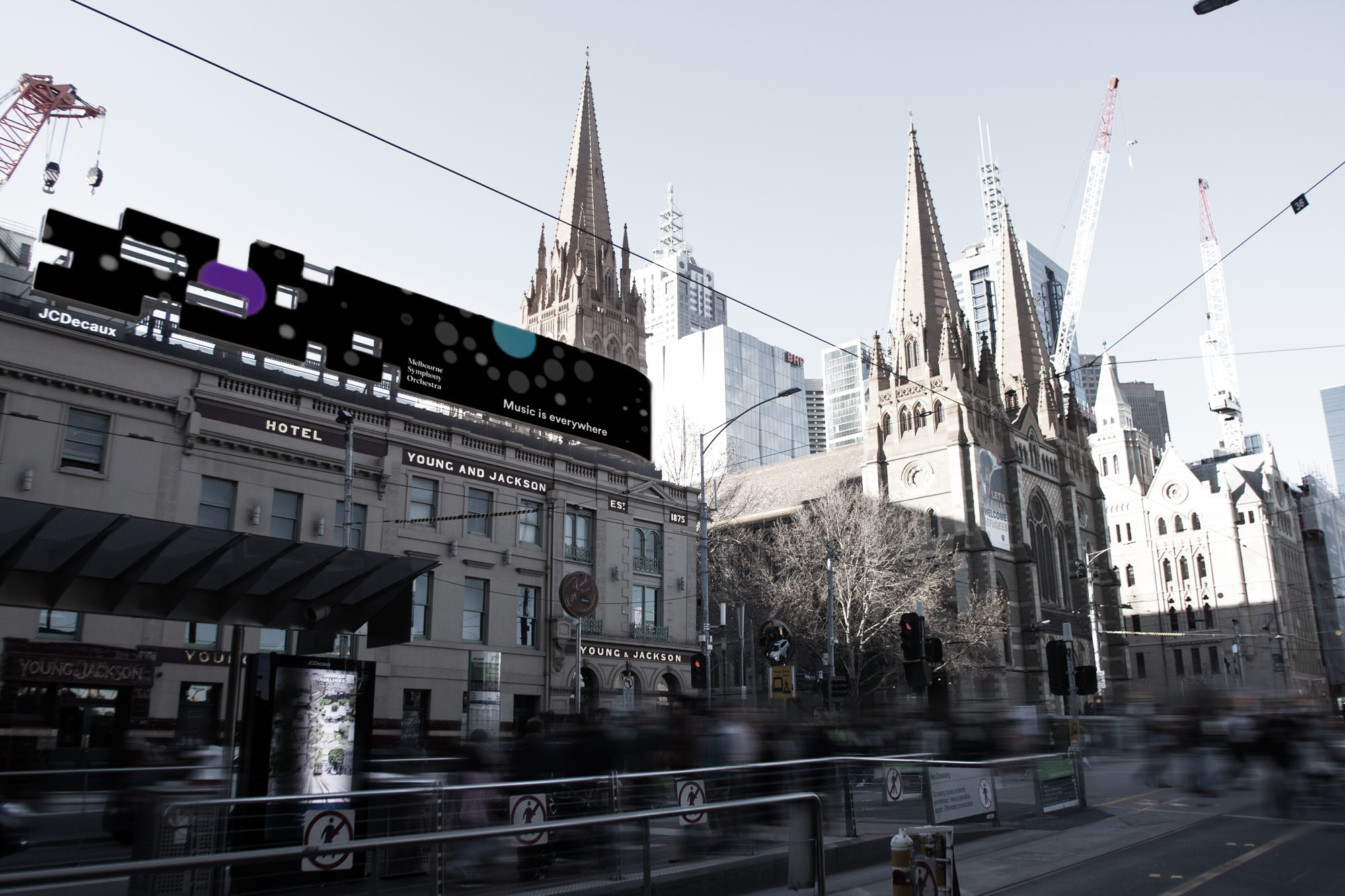 An angled image looking up over the intersection of Swanston and Flinders Streets, with a visual sound installation wrapping around the building