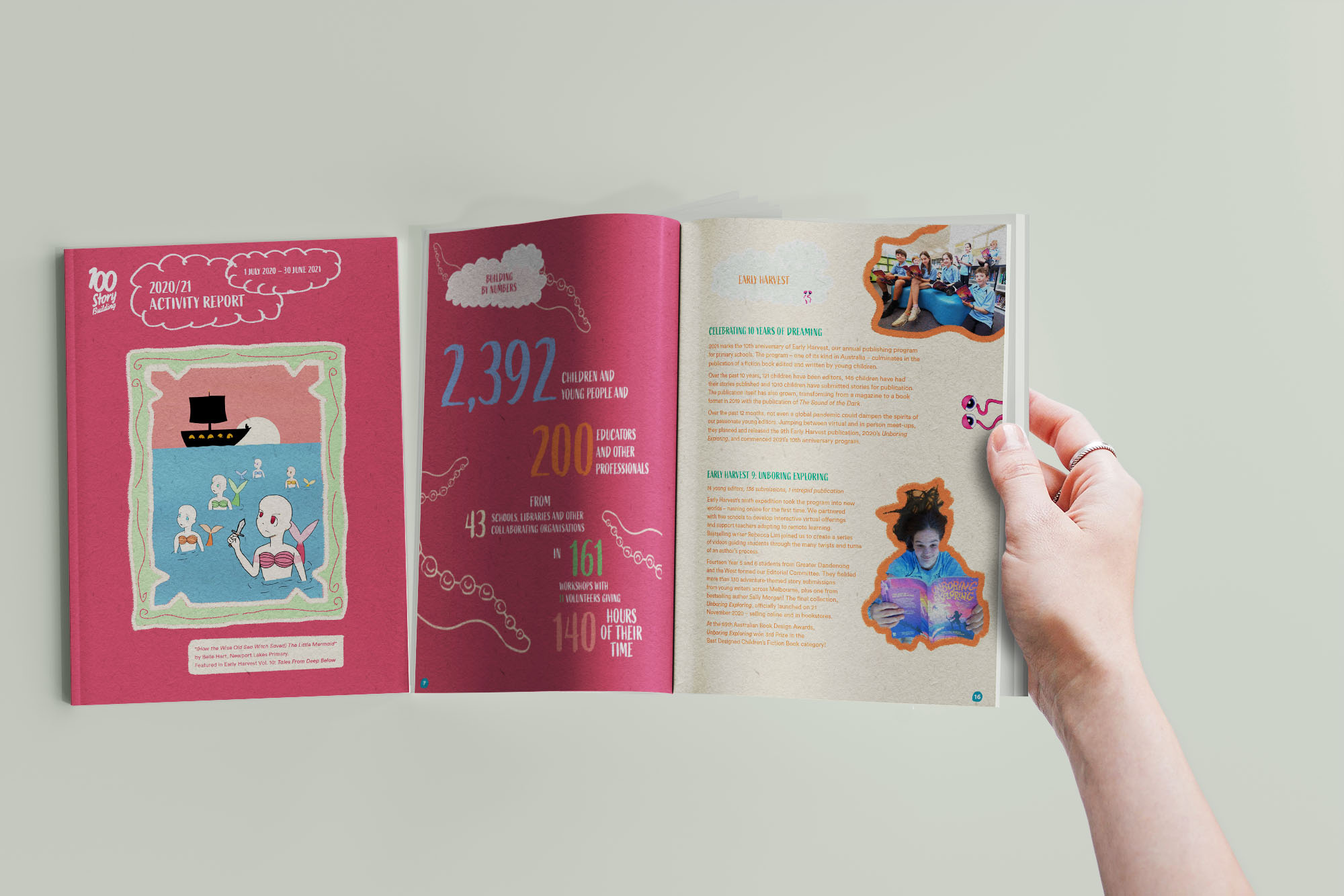 A hand holding open a spread from the 100 Story Building report and its front cover next to it