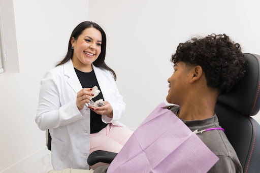 The doctor showing a young adult patient a brochure about preventive dental care options