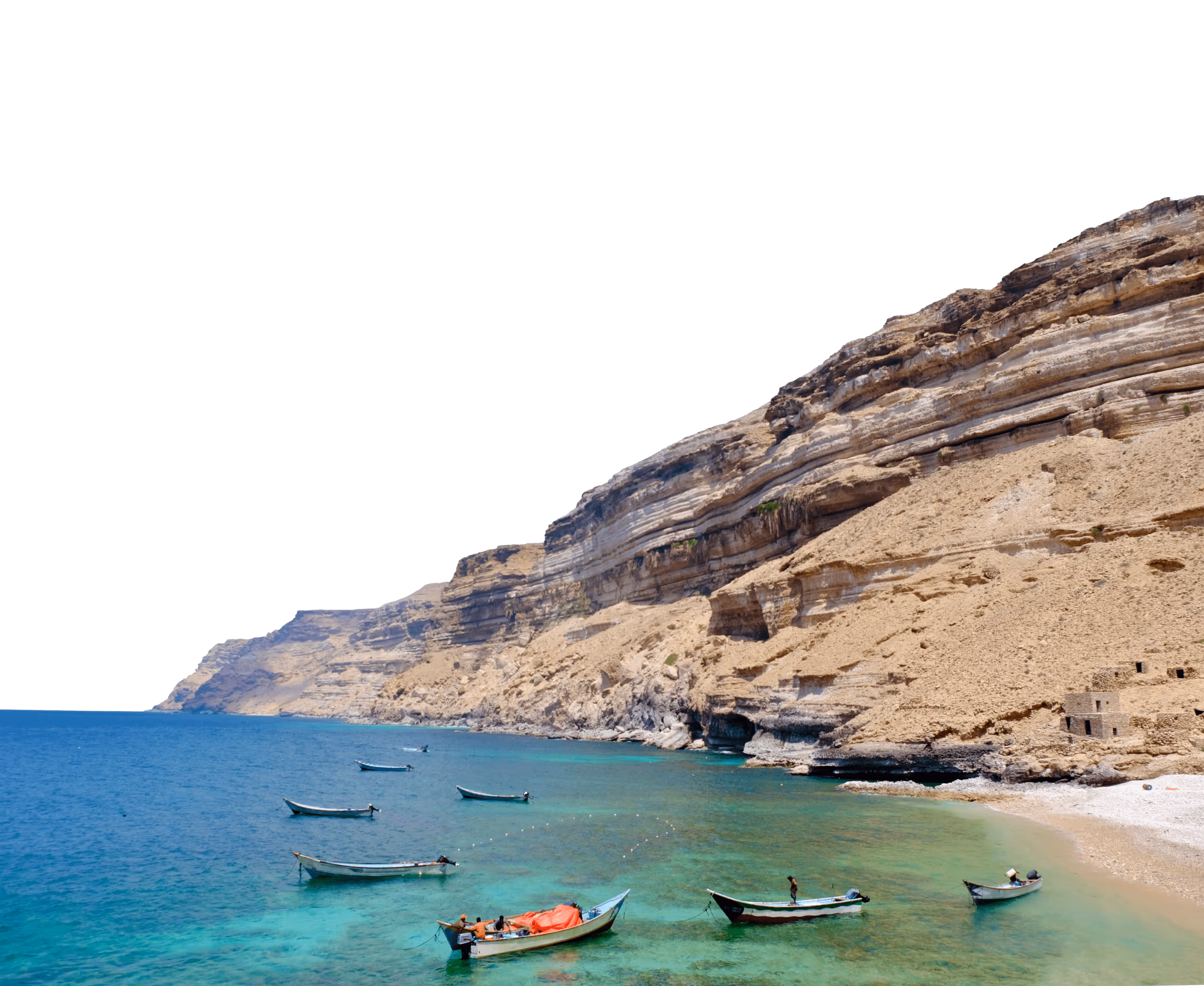 a beach with boats and a cliff