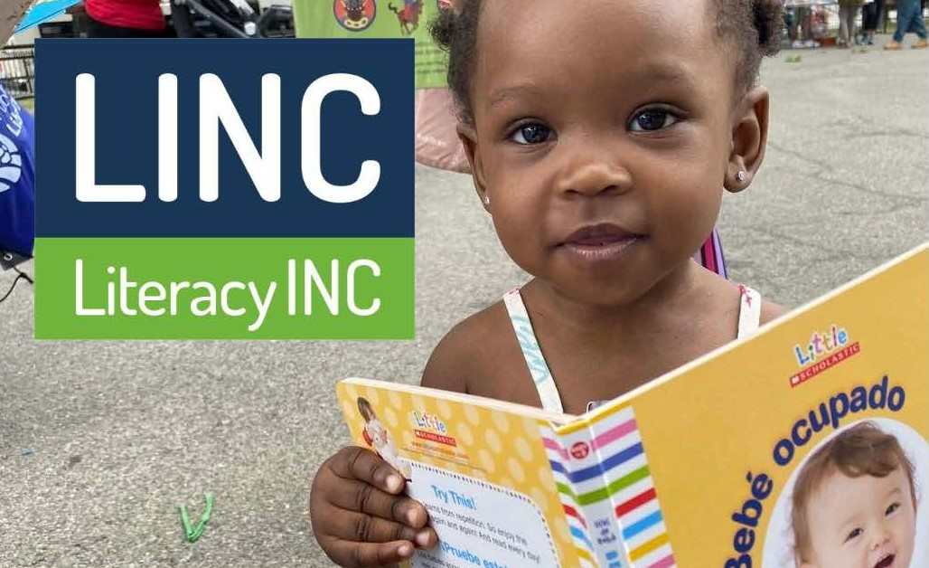 Young child reading a book during a Literacy Inc. community literacy program.