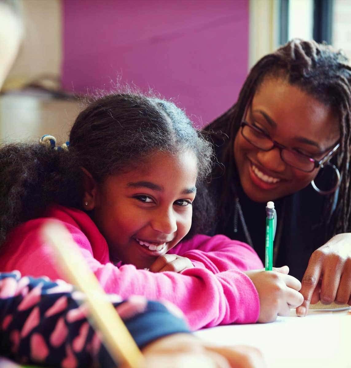 A little girl being mentored by a volunteer