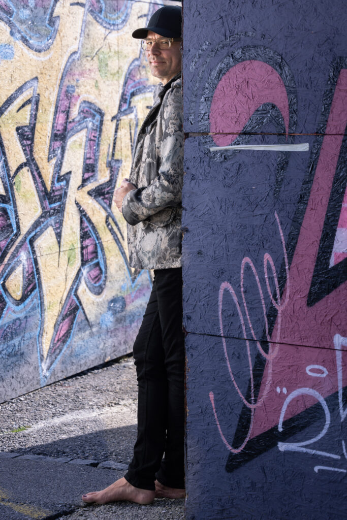 Matt Stämpfli spunta da dietro un muro con graffiti