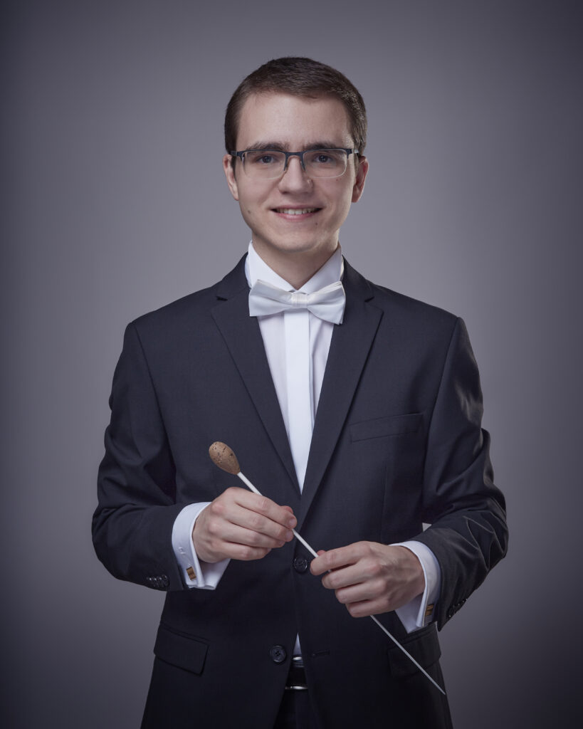 Romain Gili in Konzertanzug mit weisser Fliege und Taktstock