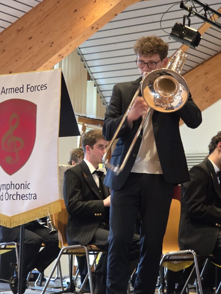 Florin Mesmer au trombone basse, accompagné par l'Orchestre symphonique à vents de la Fanfare d'armée suisse