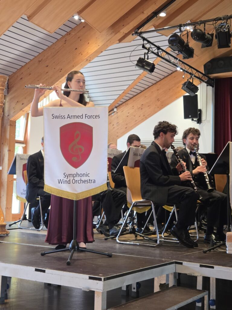 Juliette Duay à la flûte traversière, accompagnée par l'Orchestre symphonique à vents de la Fanfare d'armée suisse