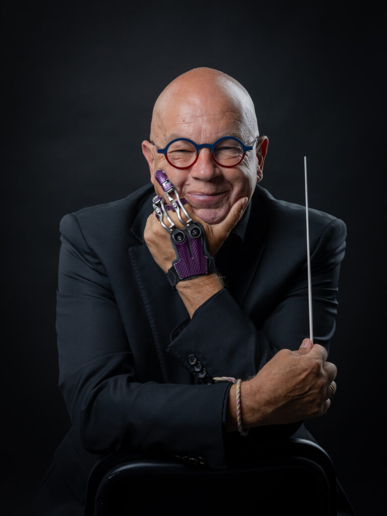 Portrait d'Armin Bachmann (Arminator) avec sa prothèse de doigt et une baguette de chef d'orchestre