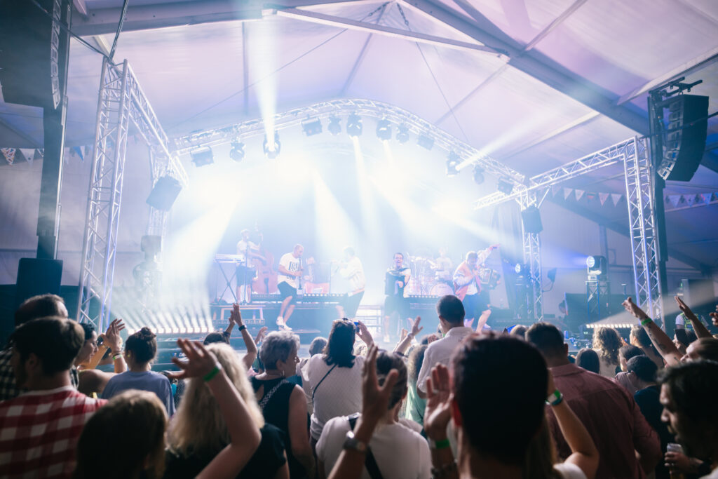 Band auf der Bühne und tanzendes Publikum