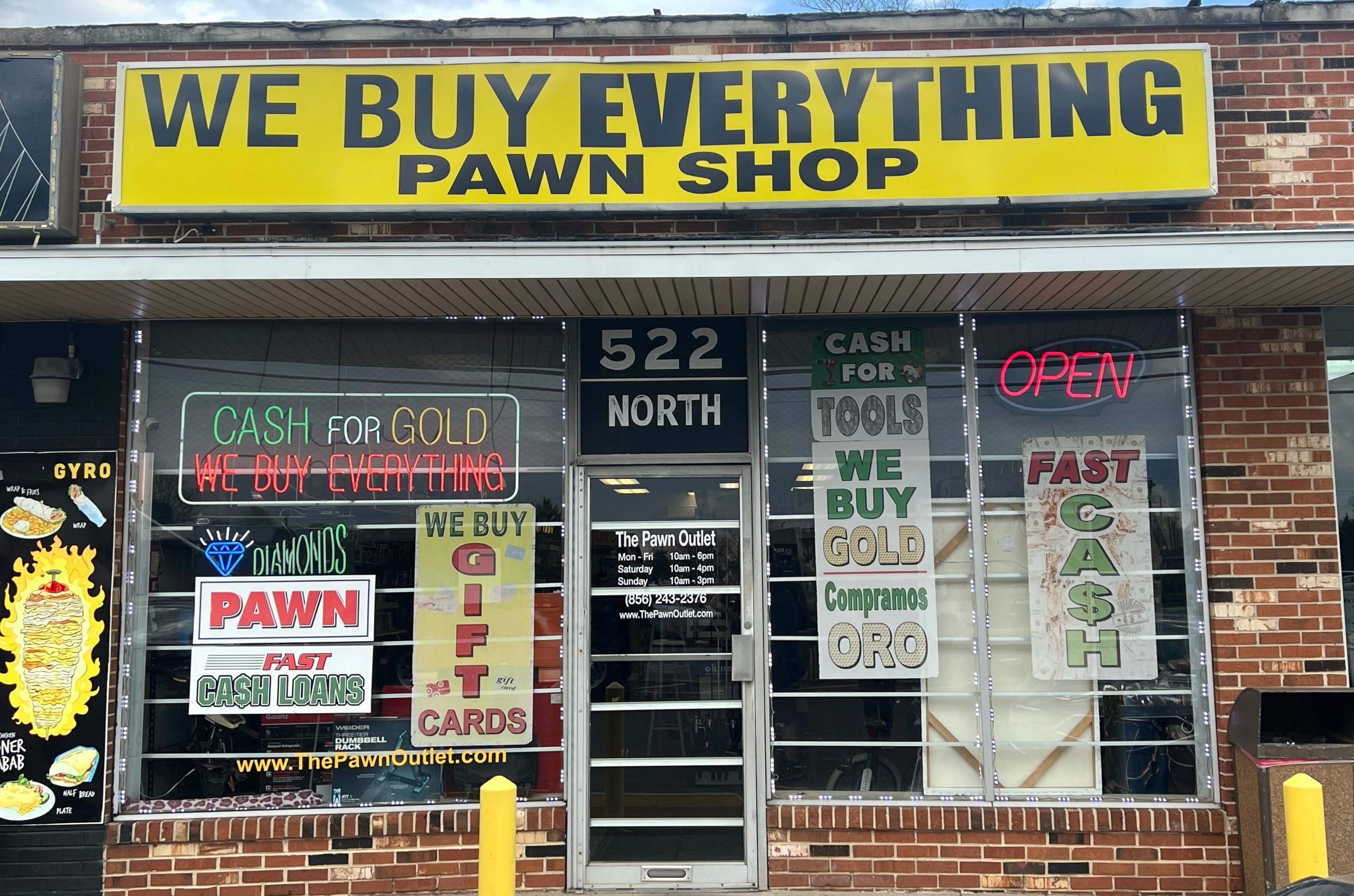Storefront of We Buy Everything Pawn Shop in Glassboro, NJ, featuring neon signs for Cash for Gold and Pawn Loans.