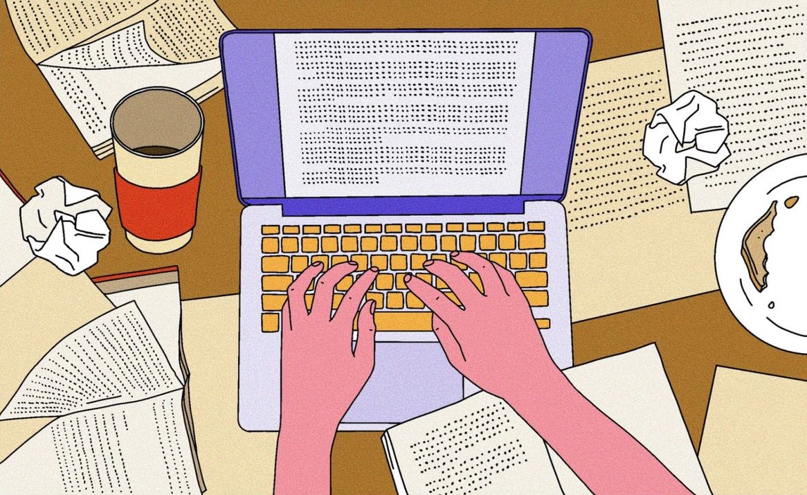 Person using a computer and writing in a notebook.