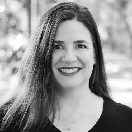 a black and white image of a woman with long brown hair smiling