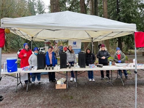 girl holding up playing card on bike in the woods