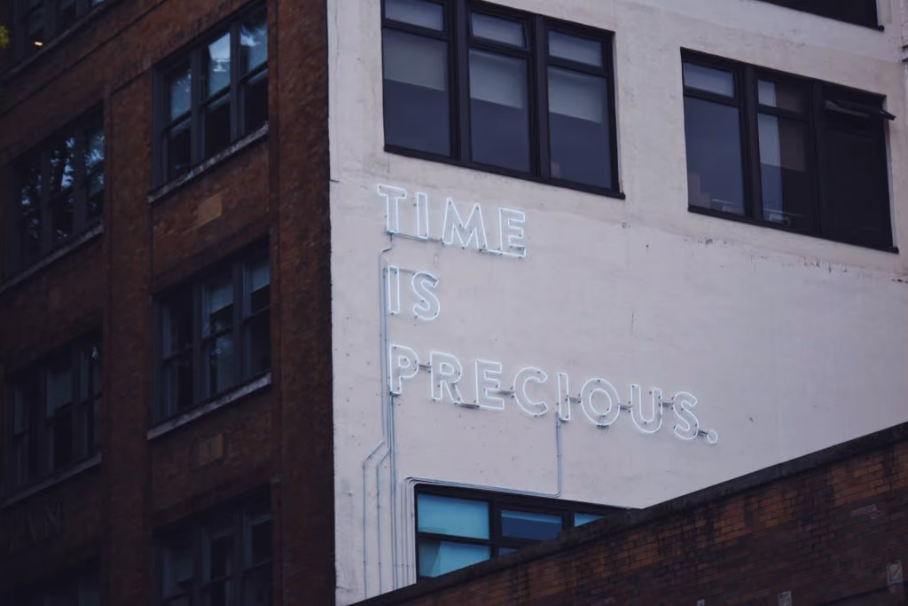 Building wall with neon sign "Time is precious"