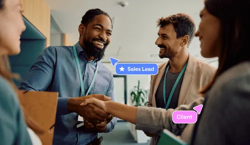 A Sales lead and client shaking hands in an office, illustrating a successful partnership.