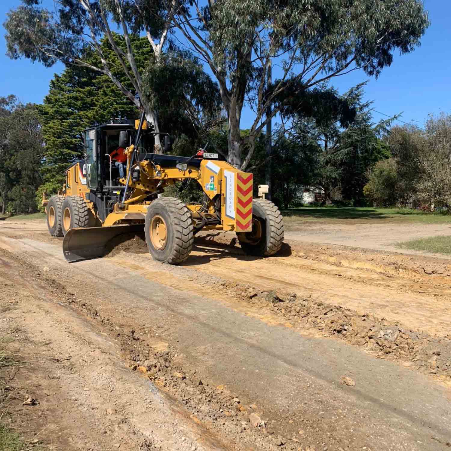 Grader pushing dirt on a new road in construction