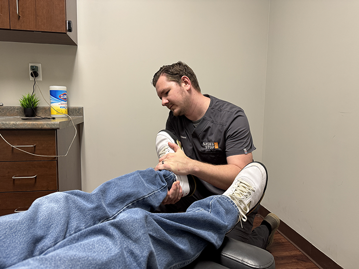 chiropractor doctor timothy hausl adjusts a patient's leg